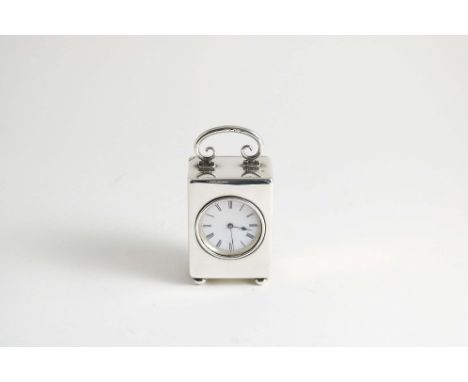A SILVER TIMEPIECE with swing handle, the movement with enamel dial, 1902, the reverse with inscription;  9 cms