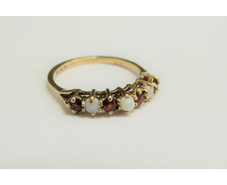 A 9ct gold garnet and opal ring. Size O/P, 1.9g 