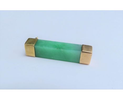 A jade oblong brooch with gold mounts, stamped 18, 3.5cm long 
