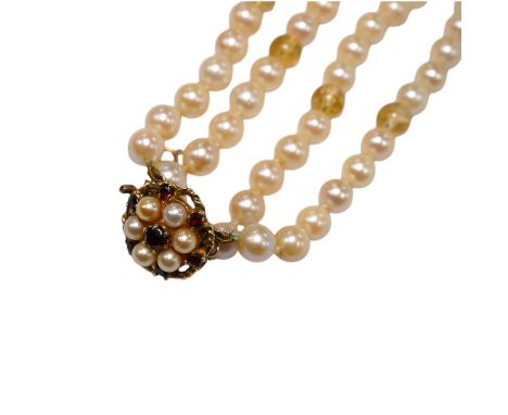 A twin strand cultured pearl choker necklace, with gem set spacers and 9ct, garnet and cultured pearl set clasp, 37cm. Condit