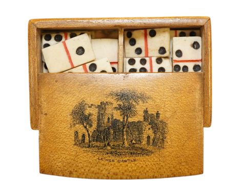 A Mauchline ware ‘Lewes Castle’ box containing a full set of bone dominoes, 5cm. Condition - fair to good