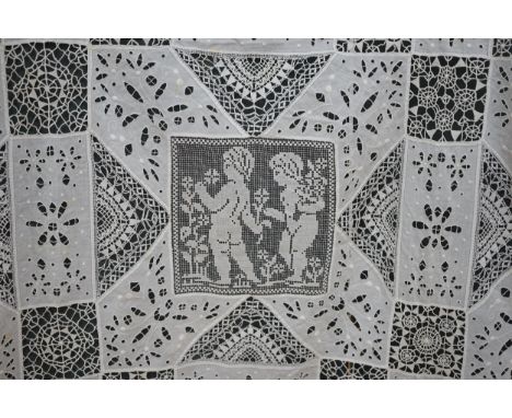 An early 20th century Italian bedcover, worked with fillet lace insertions of putti, white multi patterned fine linen cut wor