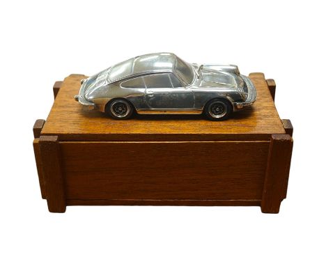 A 1:43 scale silver model of a Porsche 911, produced as a promotional model with details stamped to the base plate including;