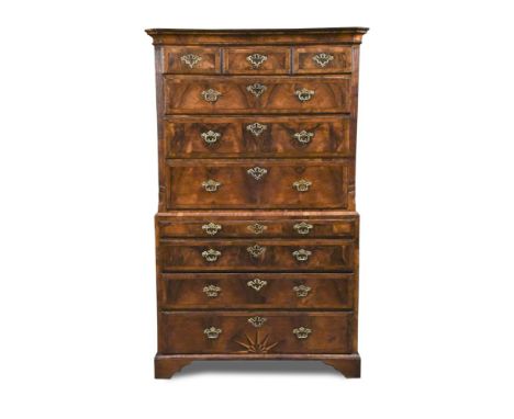 A George I figured walnut chest on chest, with banded border decoration and sunburst inlay to the lower drawer, the top half 