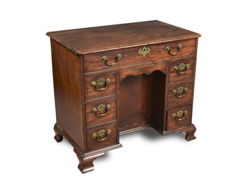 An early George III mahogany kneehole desk, with moulded border and re-entrant corners, above one long drawer, a central cupb