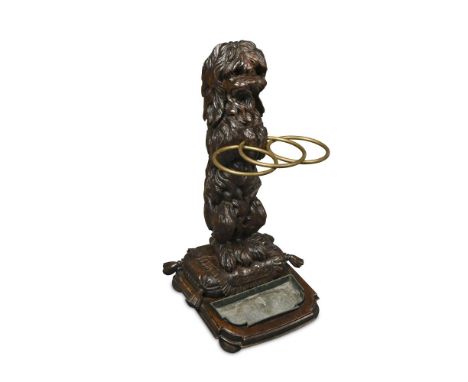 A late 19th or early 20th century Black Forest stick stand, carved as a begging Pekingese standing on its hind legs upon a 'c