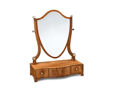 A Sheraton mahogany dressing table mirror, with a shield shaped plate and three small drawers to the serpentine base, on ogee