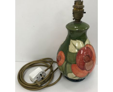 A Moorcroft floral decorated green ground tube lined table lamp with bayonet fixing approx. 25 cm high 