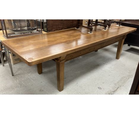 An oak dining table in the 19th Century French taste, the plank top with cleated ends over a plain frieze on square tapered l