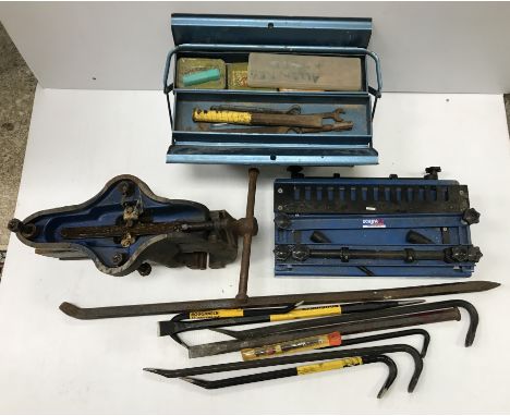 A vice/clamp together with various wrecking bars etc and a metal cantilever toolbox containing similar