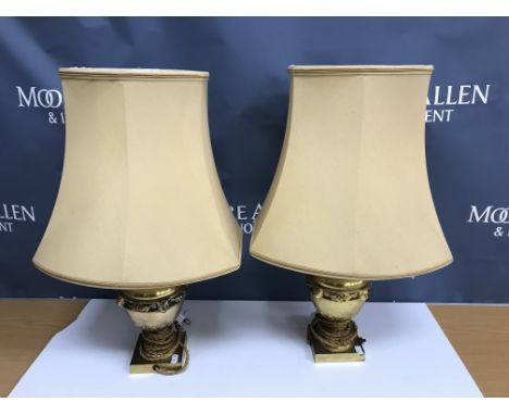 A pair of brass lion mask decorated table lamps in the Empire style raised on a square foot 26 cm high not including fittings