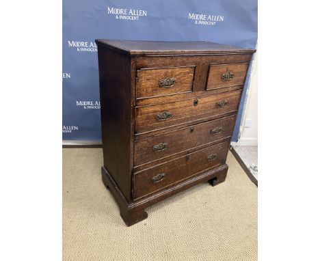 A 19th Century Provincial oak chest of two short over three long drawers with ornate brass drop handles, raised on bracket fe