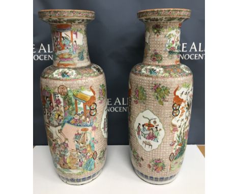 A pair of 19th Century Chinese famille rose vases, the main body decorated with panels of figures in household settings and p
