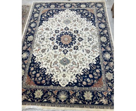 A large Indo-Persian wool carpet, the cream ground with central red brick and floral medallion, with all over floral decorati