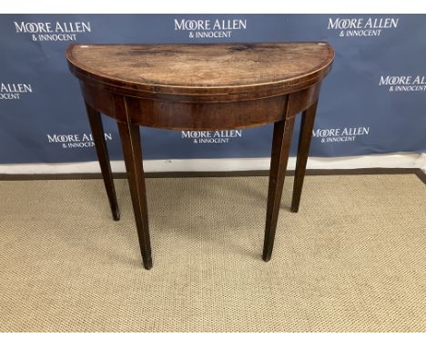 An early 19th Century mahogany and cross-banded demi-lune fold-over card table on square tapered legs, 89.5 cm wide x 74 cm h