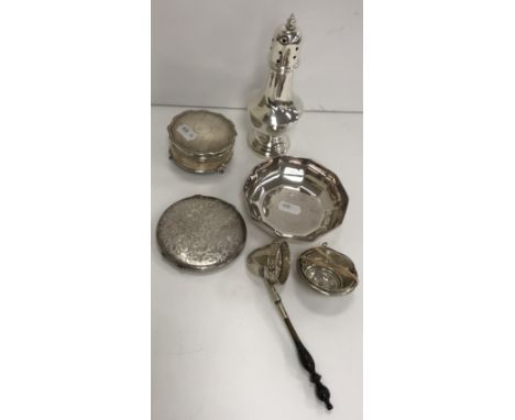 A collection of various small silver wares to include sugar shaker, dressing table jar with lined interior, powder case, an e