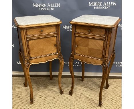 A pair of 20th Century French walnut grey veined white marble topped pot cupboards with drawers over cupboard doors enclosing