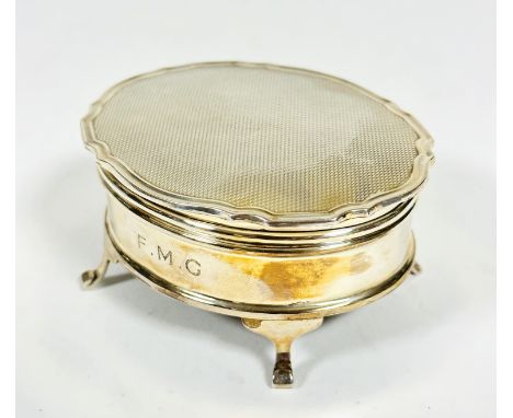 A Birmingham Mappin &amp; Webb silver oval engine turned ring box with engraved initials F.M.G raised on splay pad feet, (H x