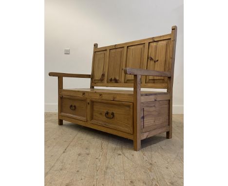 A pine hall bench, the four panel back above open arms and two drawers to base, raised on stile supports H110cm, W147cm, D70c