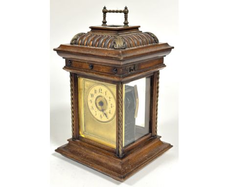 A late 19thc German musical four glass walnut carved table clock, with brass handle to fluted hinged moulded top inclosing a 