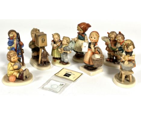 A collection of eight Hummel German pottery figures including, Doll Bath, Hear Ye, Hear Ye, etc and a small ceramic plaque. (