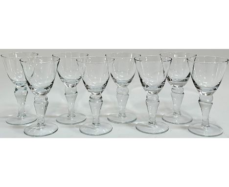 A set of eight clear drinking glasses on knopped stems (h- 16cm), together with an etched glass tumbler with architectural de