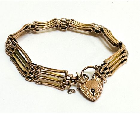 A yellow metal gate link bracelet with 9ct gold engraved heart shaped padlock and safety chain, ( D x 9cm), one section repai