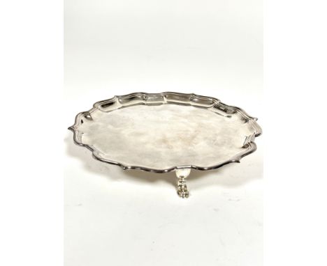 A Mappin &amp; Webb George III style presentation silver card waiter with scalloped border and raised on pad feet, inscribed 