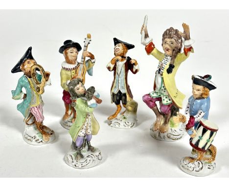 A 20thc porcelain Meissen style six piece Monkey band group of figures decorated with polychrome enamels raised on scrolling 