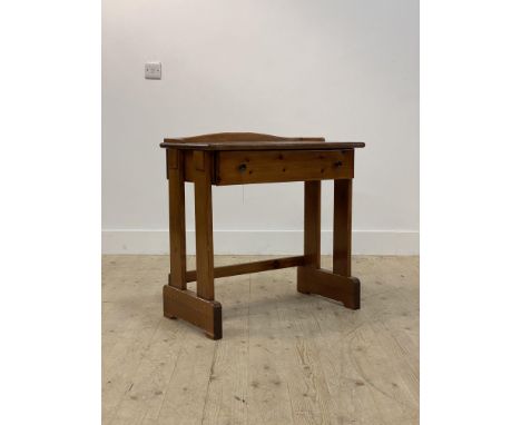 A varnished pine and mahogany side table, with ledge back over drawer, raised on four panel supports H74cm, W72cm, D43cm