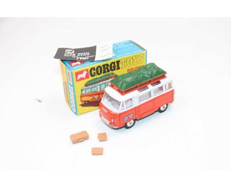 A Corgi Toys No. 508 Commer Holiday Camp bus comprising of orange and white body with three suitcases and green roof luggage 