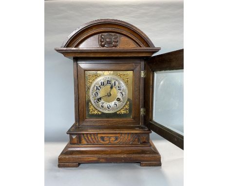 Edwardian walnut mantle clock with carved case and gilt spandrels, twin train movement, Arabic numerals, strikes on a gong, 2