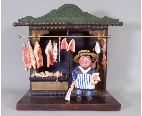 Vintage wooden model of butcher shop; butcher is in striped apron and straw hat,  holding a meat cleaver, with an array of me