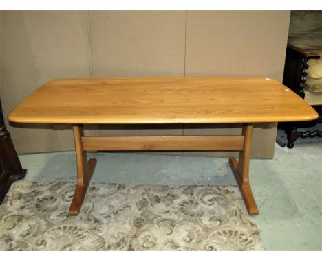 An Ercol light elm refectory style occasional table, the rectangular top with moulded outline and rounded corners raised on w