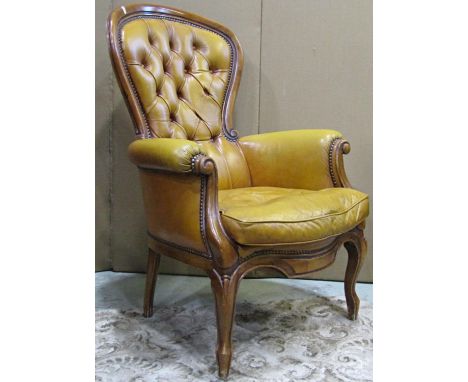 A Victorian style drawing room chair with carved and moulded show wood frame, upholstered in light tan coloured leather 