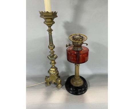 Brass Corinthian column oil lamp with cranberry reservoir together with a large brass table lamp 