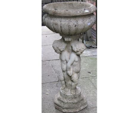 A reclaimed garden planter with circular lobed roll raised on a pedestal with standing cherub supports and stepped octagonal 