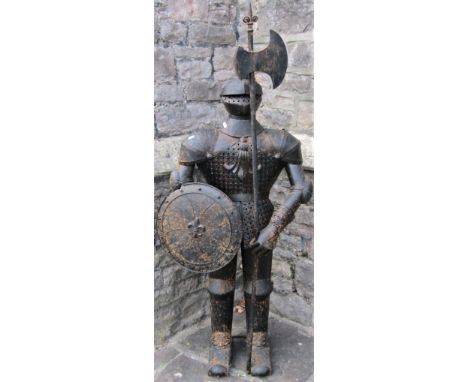 A novel hall/fireside ornament in the form of a standing knight wearing a full suit of armour holding a circular shield and l