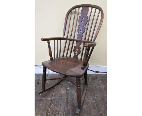 A Georgian Windsor comb back rocking chair in mixed woods, elm, yew, ash, etc, with crinoline stretcher 