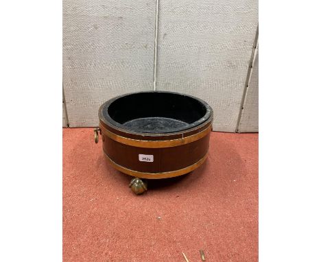 19th century mahogany and brass banded cooler, with brass ring handles raised on three ball and claw supports, 36cm diameter 