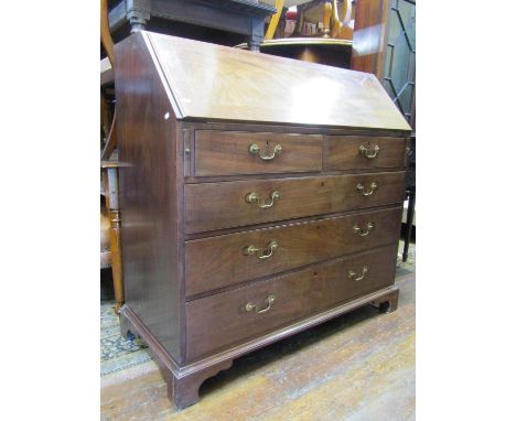 A substantial mahogany bureau of four long and two short drawers, set on bracket supports, the fall flap with simple inlaid d