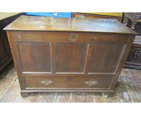 A Georgian oak mule chest with rising lid, the front elevation with panelled detail over a single long frieze drawer on brack
