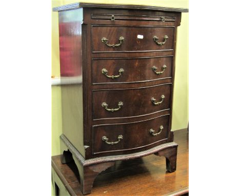 Reproduction Georgian style chest of four drawers together with a brush slide, with serpentine outline on bracket supports, 4