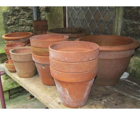 A small quantity of terracotta flower pots and planters of varying size and design, some with sprig and Greek key detail, the
