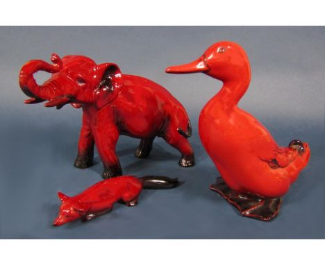 A Royal Doulton Flambe model of an elephant with raised trunk, 14 cm tall approximately, two other Royal Doulton Flambe figur