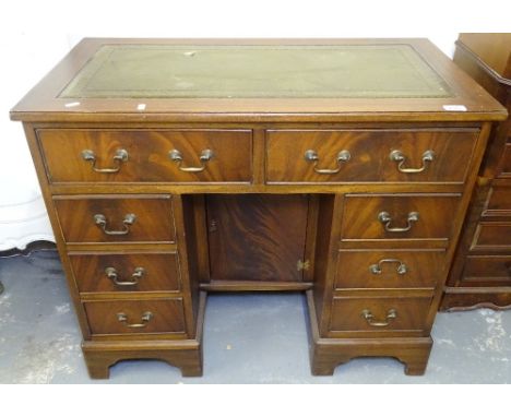 A reproduction mahogany Queen Anne style knee-hole writing desk, with fitted drawers and recessed cupboard, on bracket feet, 