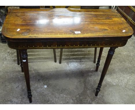 A Regency rosewood and brass inlaid fold over card table, raised on carved baluster legs, W91cm