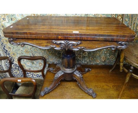 A Regency rosewood fold over card table, with applied moulded decoration, raised on a centre column and sabre leg base, W91cm