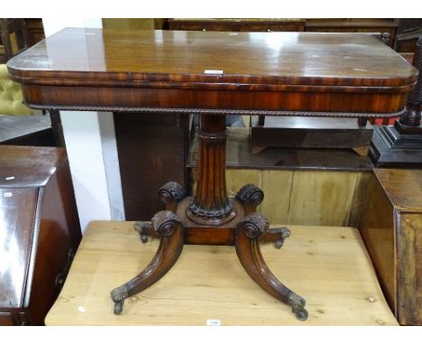 A Regency mahogany fold over card table, with tooled green leather interior, raised on a fluted centre column and sabre leg p