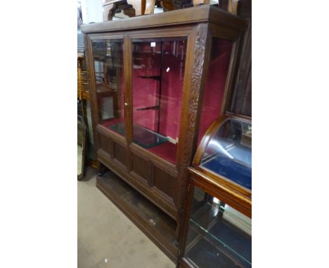 An early 20th century Continental oak display cabinet, with 2 beveled glazed and panelled doors, and open shelf below, on pli